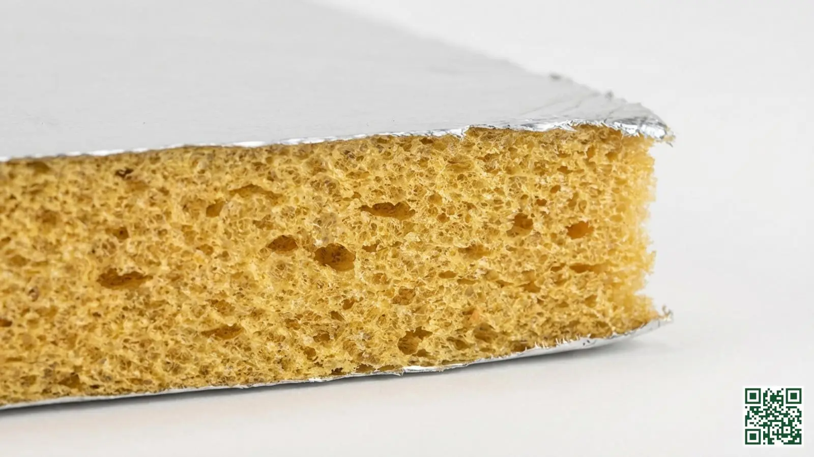 Doorsnede van een PIR isolatieplaat met zichtbare schuimkern en aluminium bekleding aan beide zijden